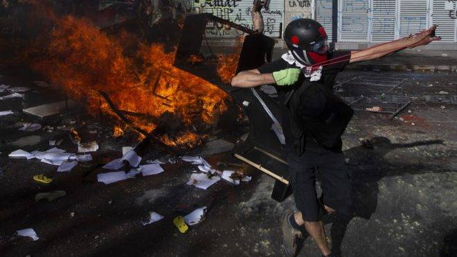 Confronto entre manifestantes e a polícia de choque em Santiago, Chile, 24 de outubro de 2019