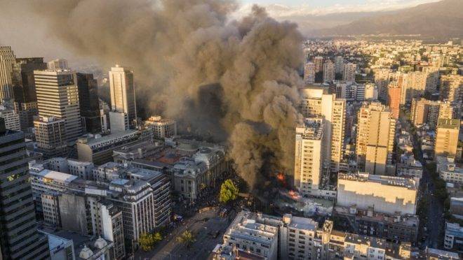 Fumaça sobe de um prédio em chamas perto do local onde manifestantes protestavam em Santiago, Chile, 28 de outubro de 2019