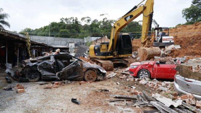 Carros ficaram soterrados sete meses debaixo do muro que desabou durante chuva.