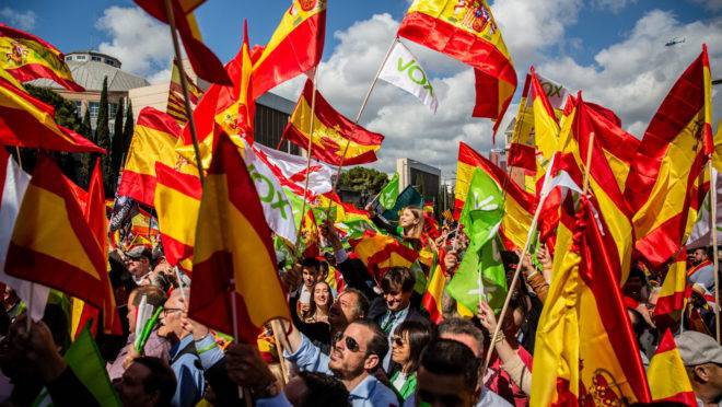 Apoiadores agitam bandeiras espanholas e do partido Vox em comício do Vox em Barcelona, Espanha, 30 de março de 2019