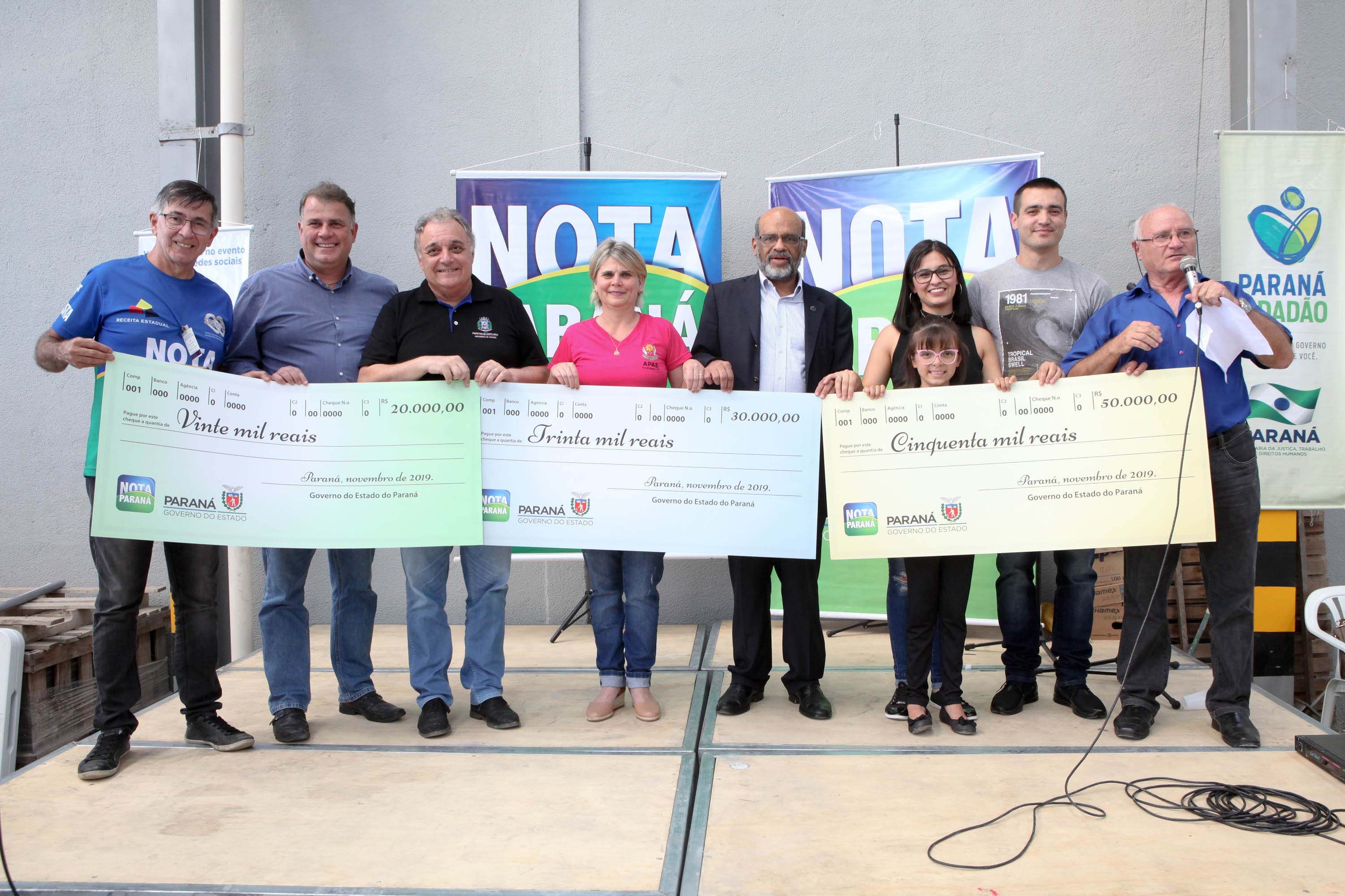Sorteados de novembro posam com os cheques do prêmio do Nota Paraná.