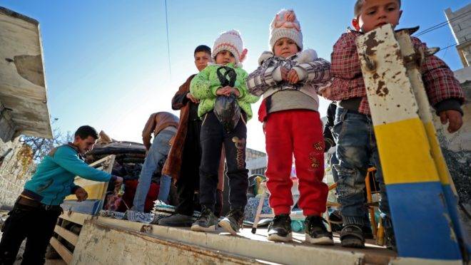 Família deixa a cidade controlada por jihadistas Maaret al-Numan, em Idlib, Síria, que estava sendo bombardeada, 20 de dezembro. Dezenas de milhares de civis estão fugindo de bombardeios em Idlib, agravando a situação humanitária