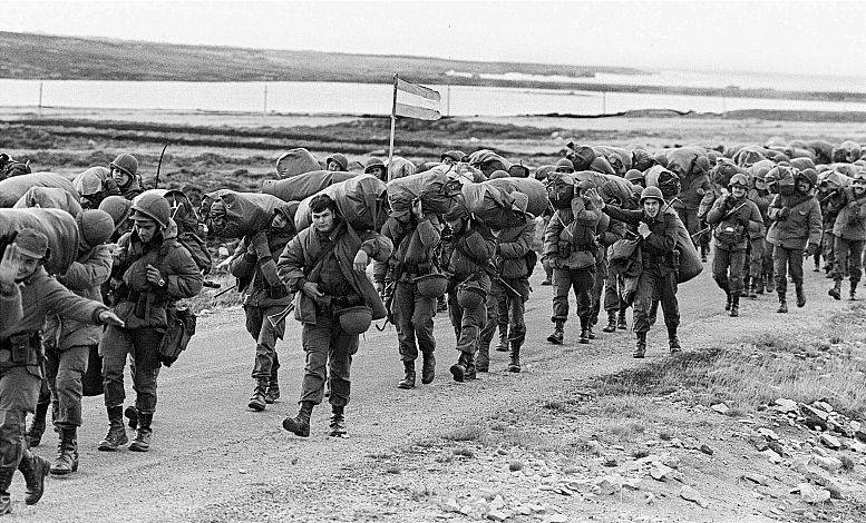 Soldados argentinos carregam suprimentos na Baía de Stanley, nas Malvinas, durante a guerra de 1982 | Arquivo AFP