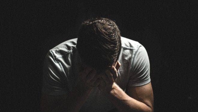 Homem com as mãos no rosto em desespero
