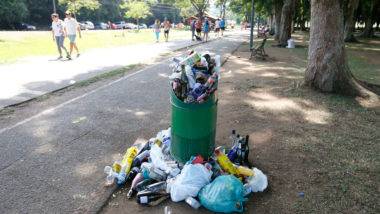 Réveillon termina com muita sujeira no Parque Barigui e voluntários ajudam na limpeza Garrafas de vidro, sacolas plásticas, garrafas de plástico e outros objetos amontoados em lixeira no Parque Barigui. Quantidade de lixo é tão grande que transborda da lixeira. Ao fundo, frequentadores do parque fazem exercícios físicos.