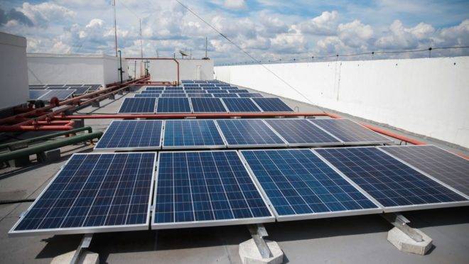 Placas solares no terraço de um prédio.