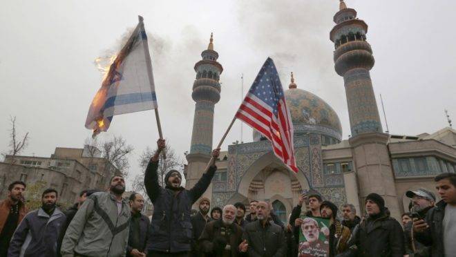Iranianos queimam bandeiras dos EUA e de Israel em protesto contra o ataque dos EUA que matou o general iraniano Qasem Suleimani. Teerã, 4 de janeiro de 2020