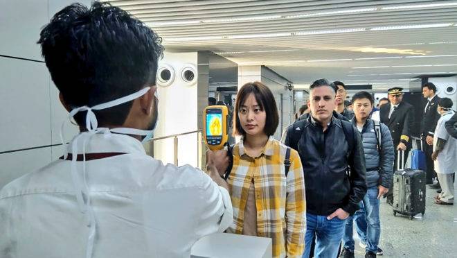 Medição de temperatura de passageiros originários da China na chegada ao aeroporto de Calcutá