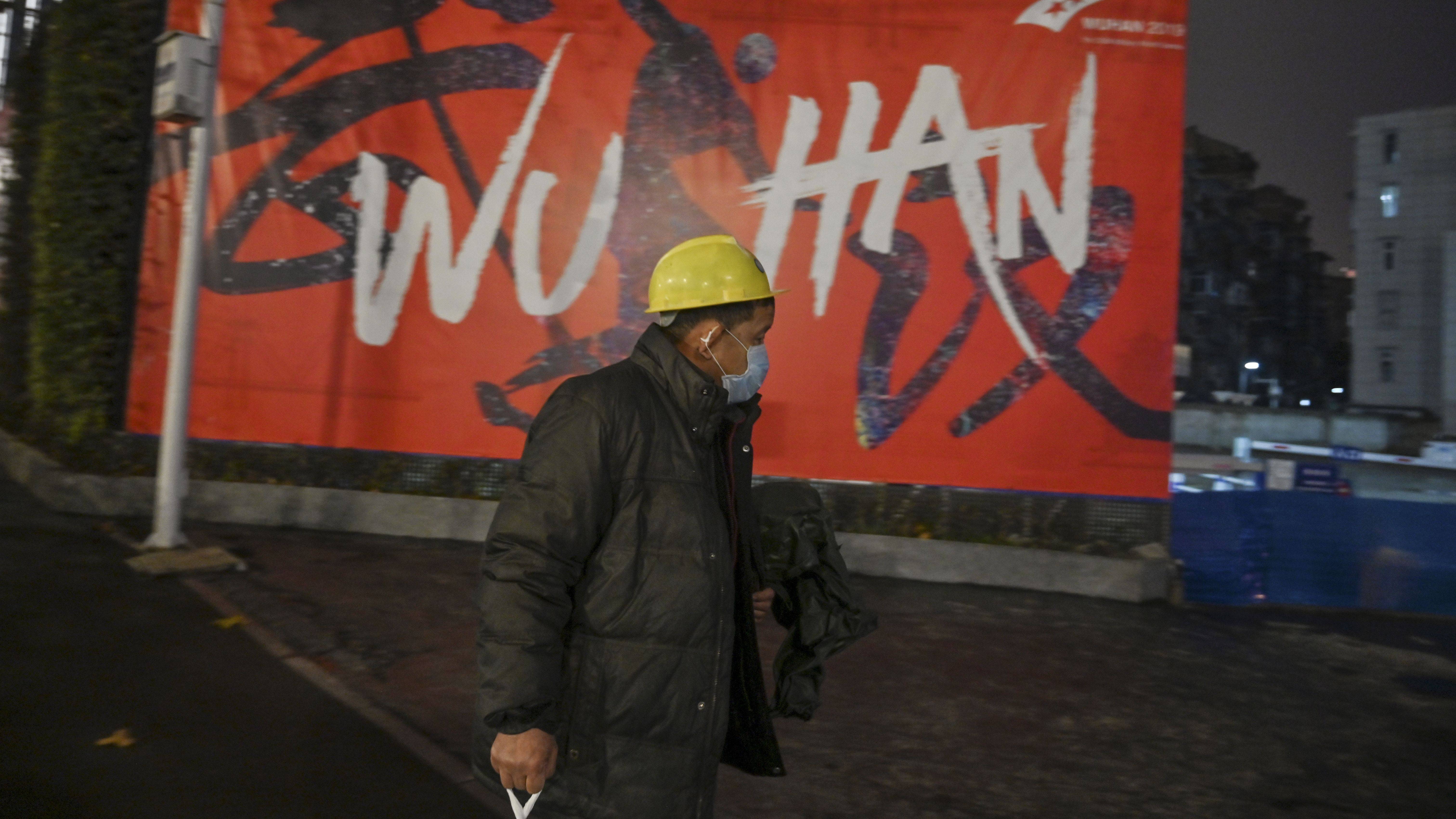 Homem usando máscara caminha em Wuhan