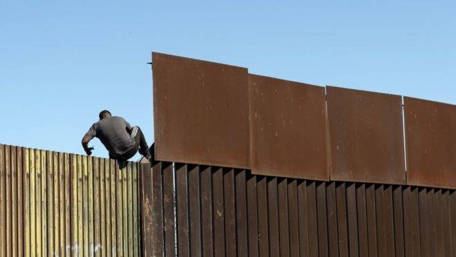 Homem atravessa barreira na fronteira entre México e Estados Unidos, em Mexicali, 11 de fevereiro de 2020