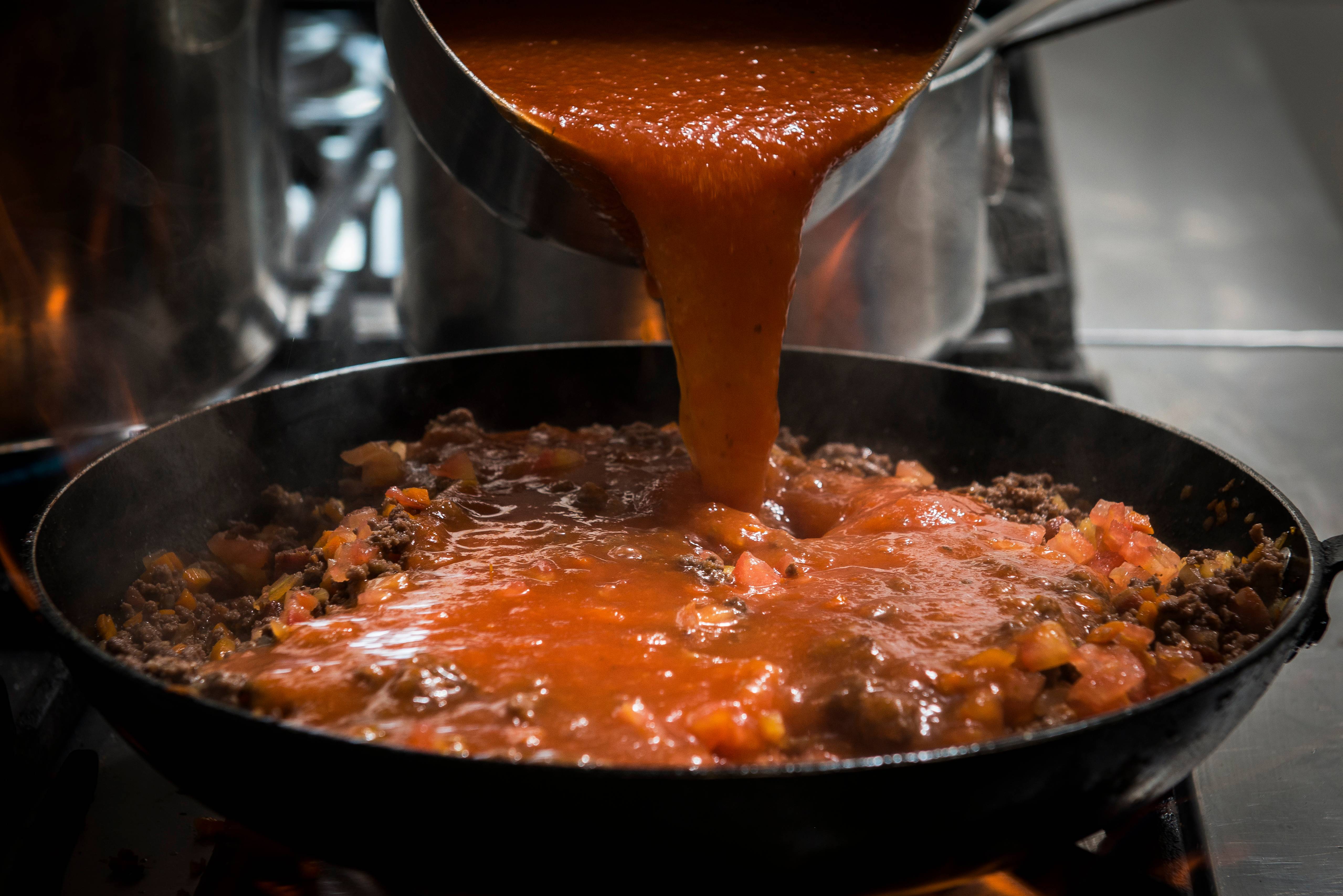 6. Espere secar e junte o molho e os pedaços de tomate. Cozinhe por cerca de 30 minutos para engrossar o molho e diminuir a acidez. 6. Espere secar e junte o molho e os pedaços de tomate. Cozinhe por cerca de 30 minutos para engrossar o molho e diminuir a acidez.