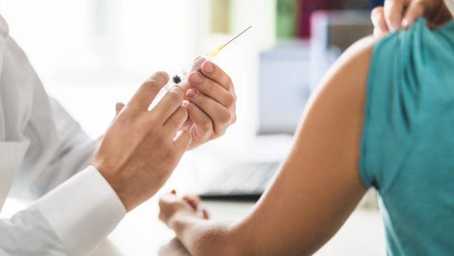 Doctor, patient and injection needle. Physician or nurse giving vaccine, flu or influenza shot in office room in hospital. Immunity, health care or HPV concept. Medical professional working.