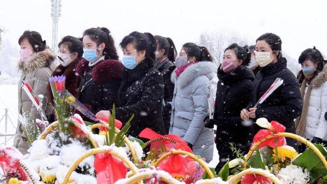 Pessoas em frente às estátuas dos líderes norte-coreanos Kim Il Sung e Kim Jong Il em Pyongyang para celebrar o aniversário de 78 anos de Kim Jong Il, 17 de fevereiro de 2020