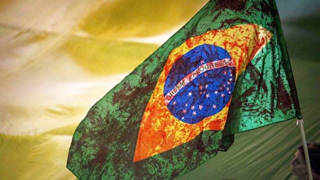 bandeira do Brasil manchada de vermelho.