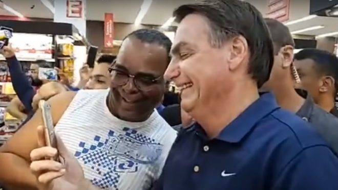 Bolsonaro tira foto ao lado de admirador, no Guarujá, litoral de São Paulo.