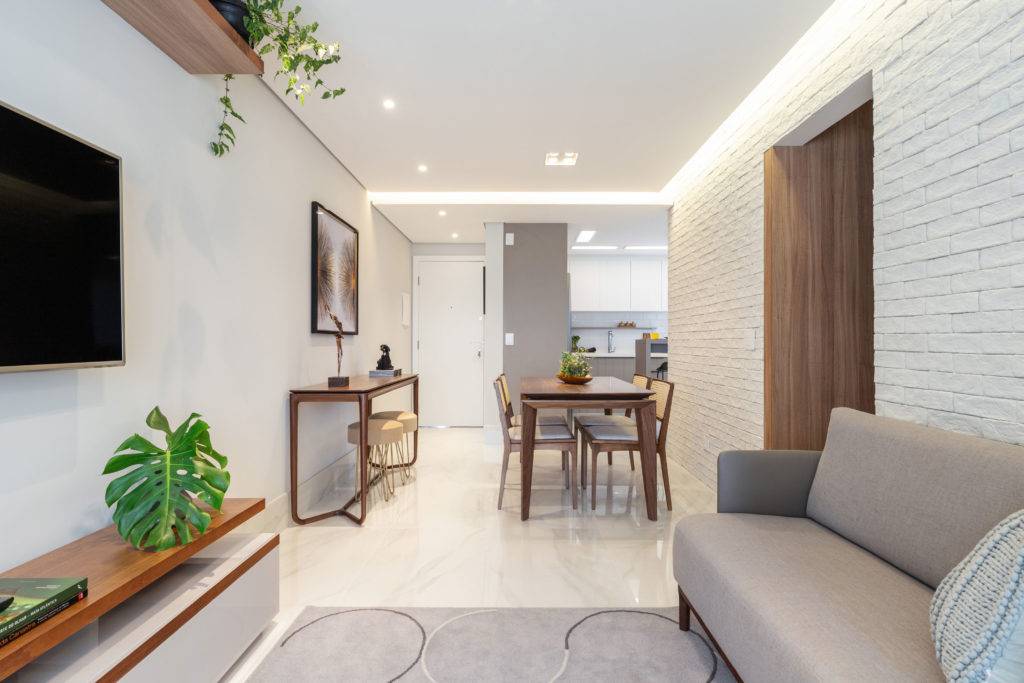 Sala de jantar e estar integradas, com destaque para a parede de tijolinho branco da Kyoto Pedras. Foto: Maura Mello / divulgação. Sala de jantar e estar integradas, com destaque para a parede de tijolinho branco da Kyoto Pedras. Foto: Maura Mello / divulgação.