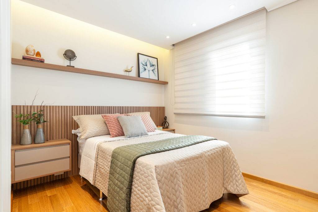 Suíte com piso e rodapés em madeira que trazem a sensação de conforto. O destaque fica para a marcenaria da cabeceira da cama. Foto: Maura Mello / divulgação. Suíte com piso e rodapés em madeira que trazem a sensação de conforto. O destaque fica para a marcenaria da cabeceira da cama. Foto: Maura Mello / divulgação.
