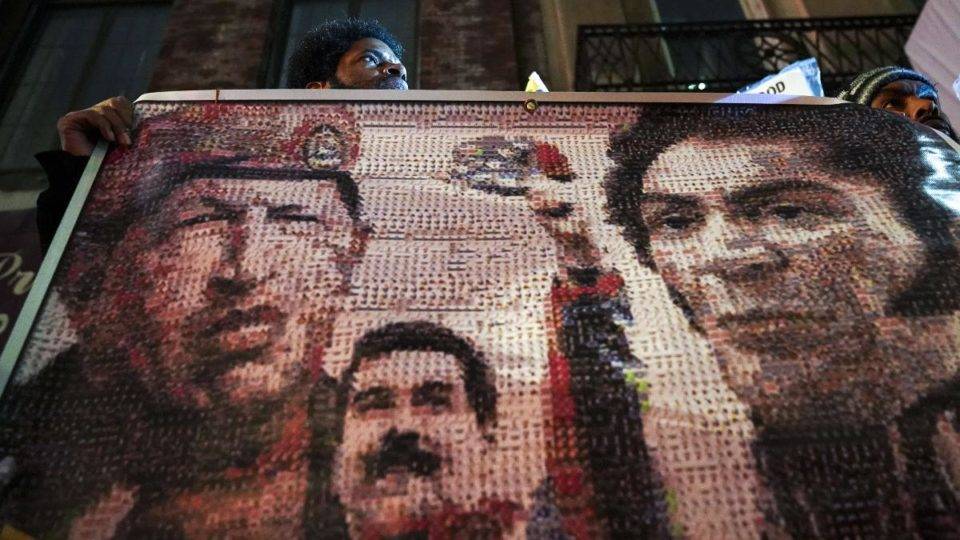 Manifestantes apoiam o presidente venezuelano, Nicolas Maduro, segurando uma faixa com o ex-presidente da Venezuela Hugo Chávez, o atual presidente da Venezuela, Nicolás Maduro, e o líder militar e político venezuelano Simon Bolívar, do lado de fora do Consulado da Venezuela em Nova York. | Drew Angerer/AFP