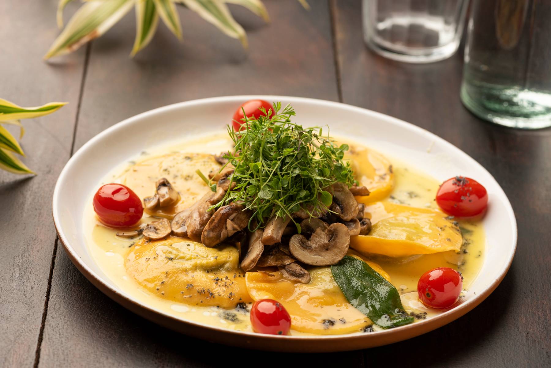 Ravioli recheado com creme de espinafre, finalizado na manteiga de sálvia, e servido com tomate cereja e cogumelos grelhados, que pode ser escolhido em substituição ao prato principal no La Vaca Steakhouse. Ravioli recheado com creme de espinafre, finalizado na manteiga de sálvia, e servido com tomate cereja e cogumelos grelhados, que pode ser escolhido em substituição ao prato principal no La Vaca Steakhouse.