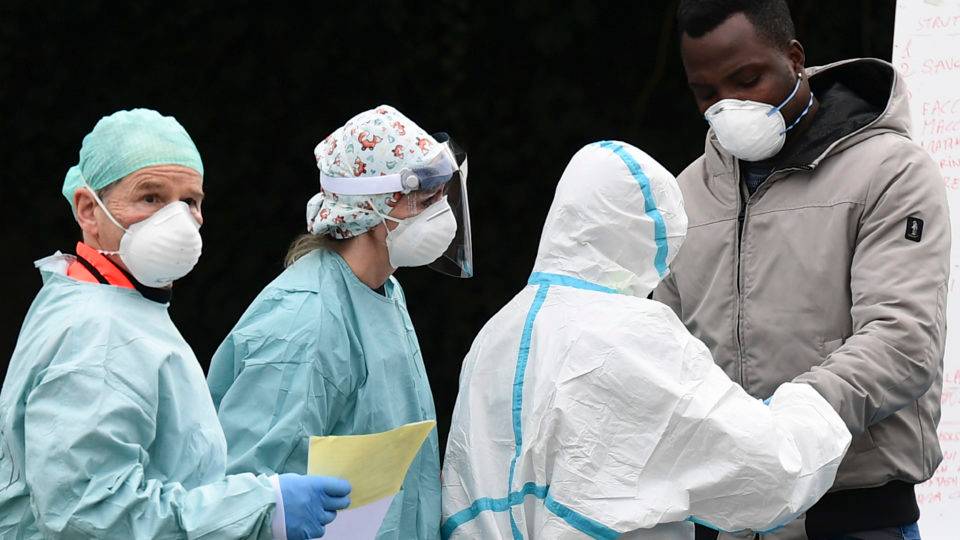 Avanço do coronavírus em outros países mostra que Brasil pode ter 30 mil casos até 1.º de abril Funcionários de hospital na Itália, usando máscaras, fazem atendimento a possível paciente de coronavírus.