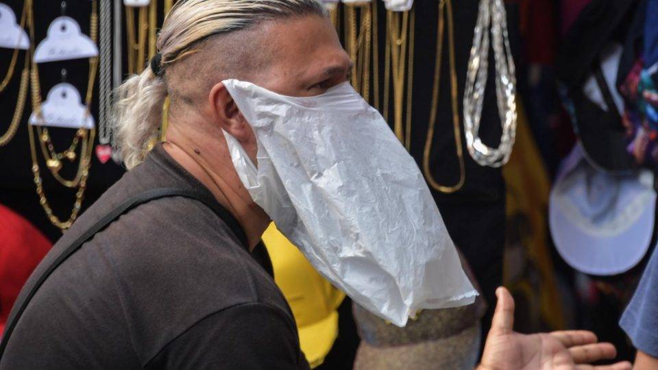 Vendedor ambulante Homem improvisa sacola plástica como máscara para se proteger da pandemia de coronavírus, em São Paulo.