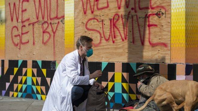 Médico conversa com moradores de rua de São Francisco sobre o coronavírus.