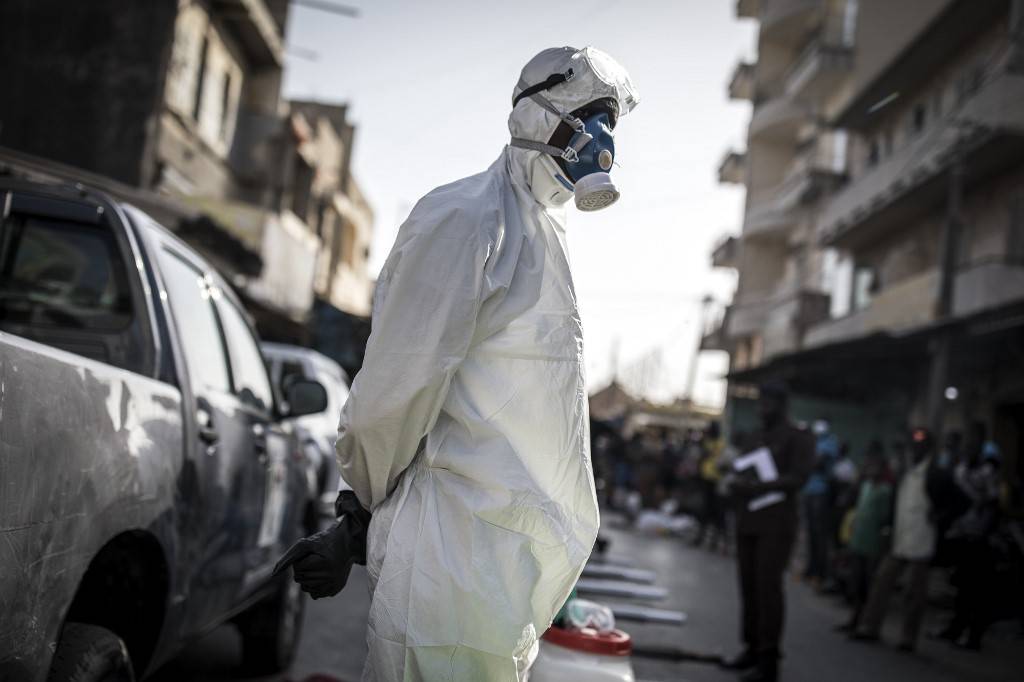 Funcionário usa equipamento de proteção completo como medida preventiva contra o coronavírus, em Dakar, em 22 de março de 2020.
