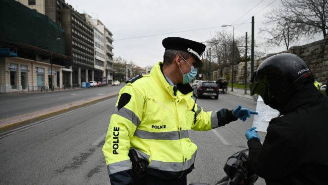 Policial grego aborda motociclista por causa do coronavírus.