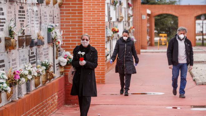 Pessoas usando máscaras chegam ao cemitério Municipal do Sul em Madri, em 23 de março de 2020, para um enterro de uma pessoa que morreu de coronavírus