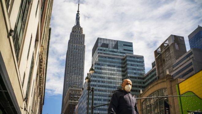 Usando máscara, homem caminha por Nova York. O estado é o epicentro do coronavírus nos EUA.