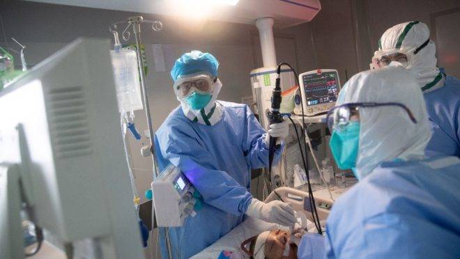 Equipe médica trata paciente com coronavírus em um hospital de Wuhan, na província central de Hubei, na China (19 de março de 2020).