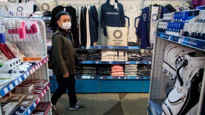 Homem usando máscara visita loja oficial das Olimpíadas de Tóquio na capital japonesa
