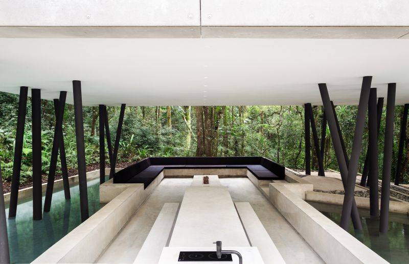 Na parte externa e inferior da casa, o jardim e a área gourmet são conectados e conversam com a topografia do terreno. Foto: MCA Estúdio Na parte externa e inferior da casa, o jardim e a área gourmet são conectados e conversam com a topografia do terreno. Foto: MCA Estúdio