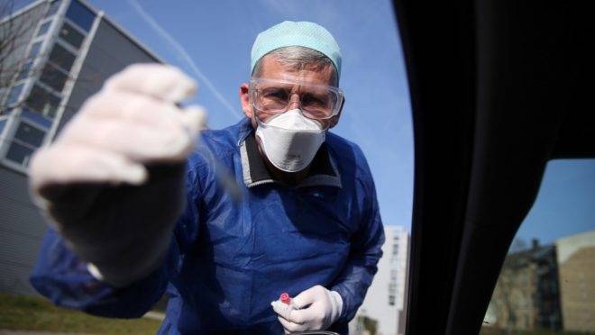 Médico recolhe amostra de motorista para teste de covid-19 em Halle, Alemanha, 27 de março de 2020