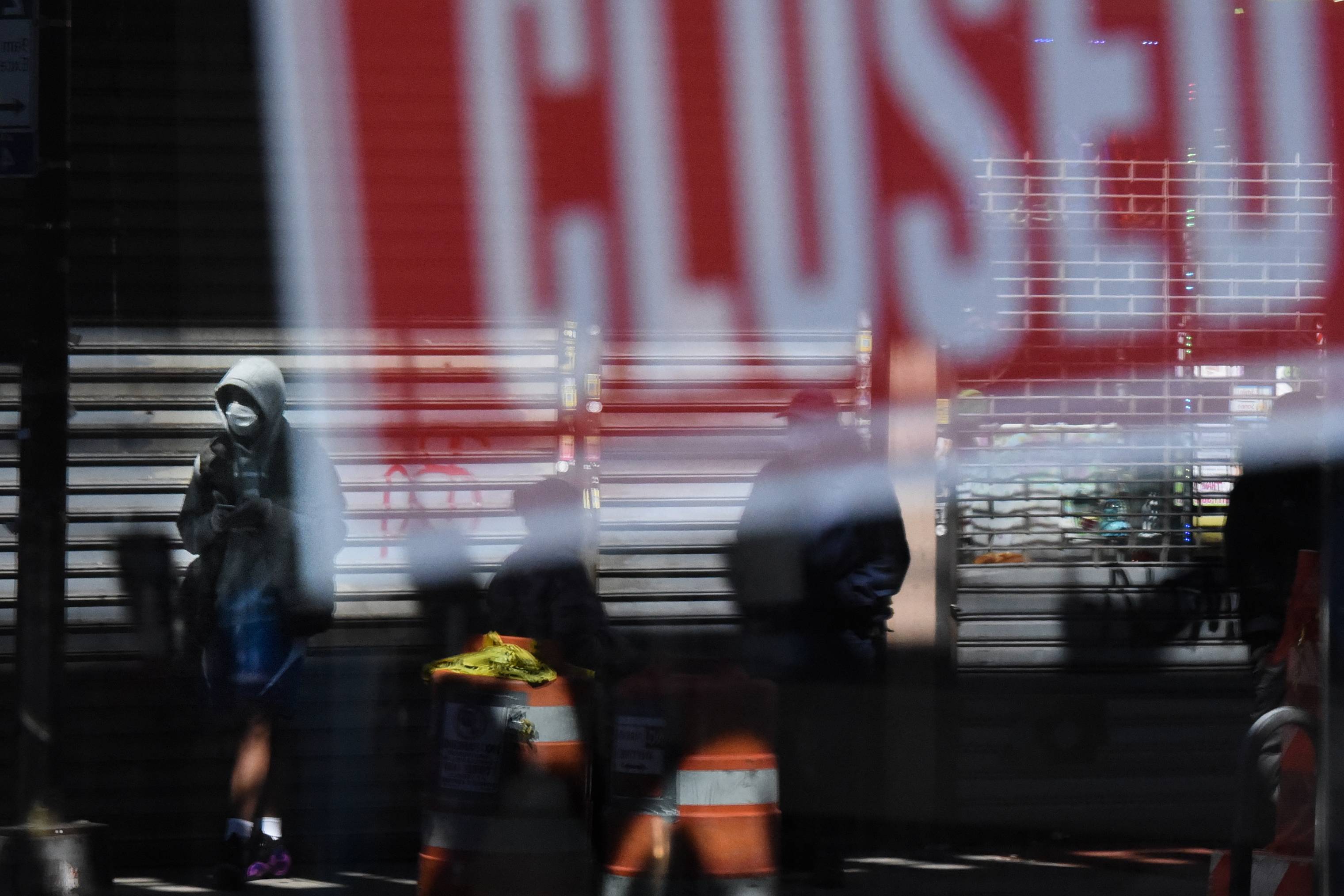 Comércios fechados e pessoas com máscaras nas ruas de Elmhurst, bairro de Nova York onde 27% da população vive na pobreza