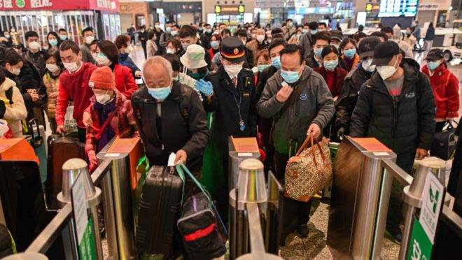 Pessoas em estação de trem em Shangai, China, se dirigem a trem que passa por Wuhan, 28 de março de 2020
