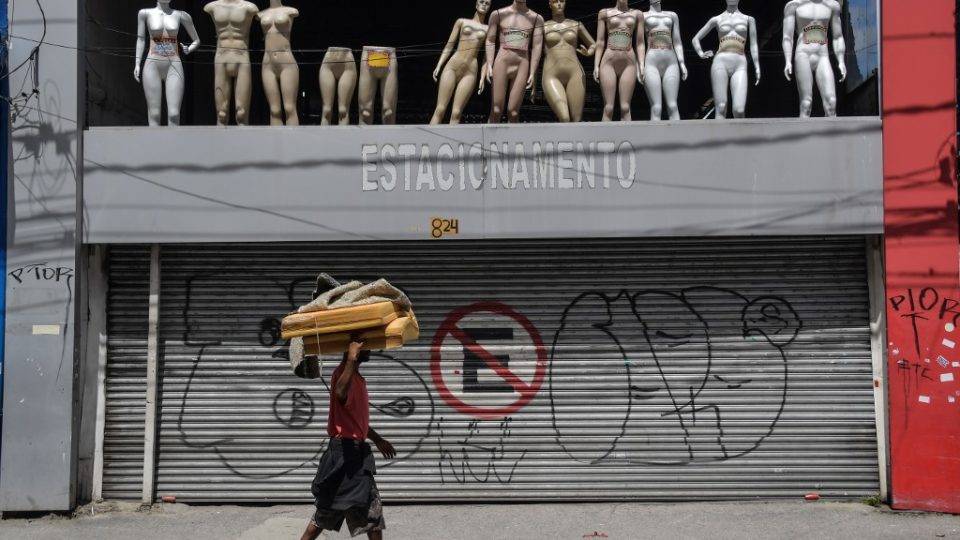 Isolamento social em São Paulo é de 57%, aponta sistema de monitoramento Morador de rua passa em frente a loja fechada em São Paulo, capital.
