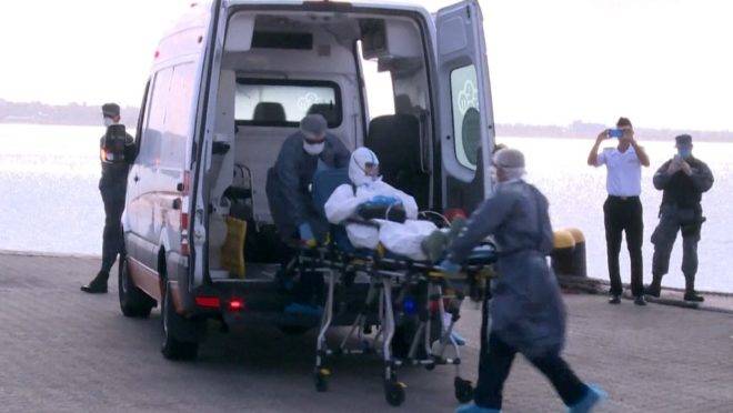 Australiano de 75 anos que estava a bordo do navio australiano Greg Mortimer é transportado para ambulância com sintomas de infecção por coronavírus, 3 de abril. Mais de 80 pessoas a bordo do navio, ancorado no Uruguai, tiveram resultado positivo para covid-19