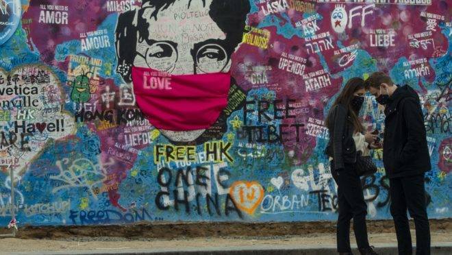 Casal em frente ao “Muro do Lennon” em Praga, 6 de abril. A maioria das atividades diminuiu ou parou na República Tcheca para conter a propagação da covid-19