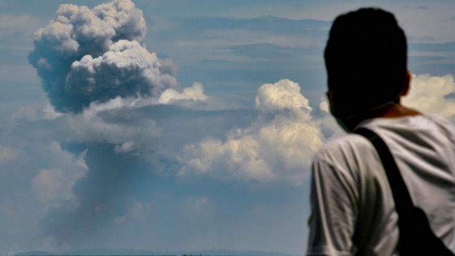 Homem observa o vulcão Anak Krakatau durante erupção em Serang, Indonésia, 11 de abril de 2020