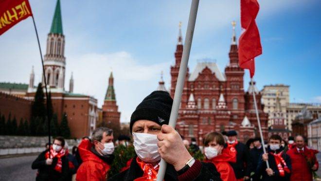 Apoiadores e membros do partido comunista da Rússia caminham para o mausoléu de Lênin, na Praça Vermelha, Moscou, para celebrar os 150 anos do nascimento do líder bolchevique, em meio à pandemia de coronavírus, 22 de abril de 2020