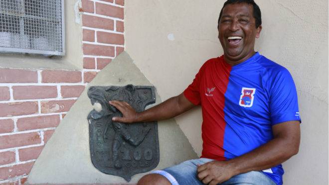 Saulo ao lado da placa comemorativa aos seus 100 gols, na Vila Capanema.