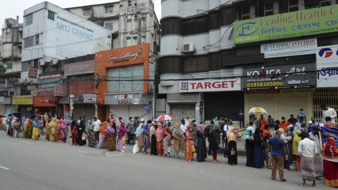 Pessoas na fila para receber alimentos durante confinamento imposto pelo governo durante a pandemia de coronavírus em Dhaka, Bangladesh, 26 de abril de 2020