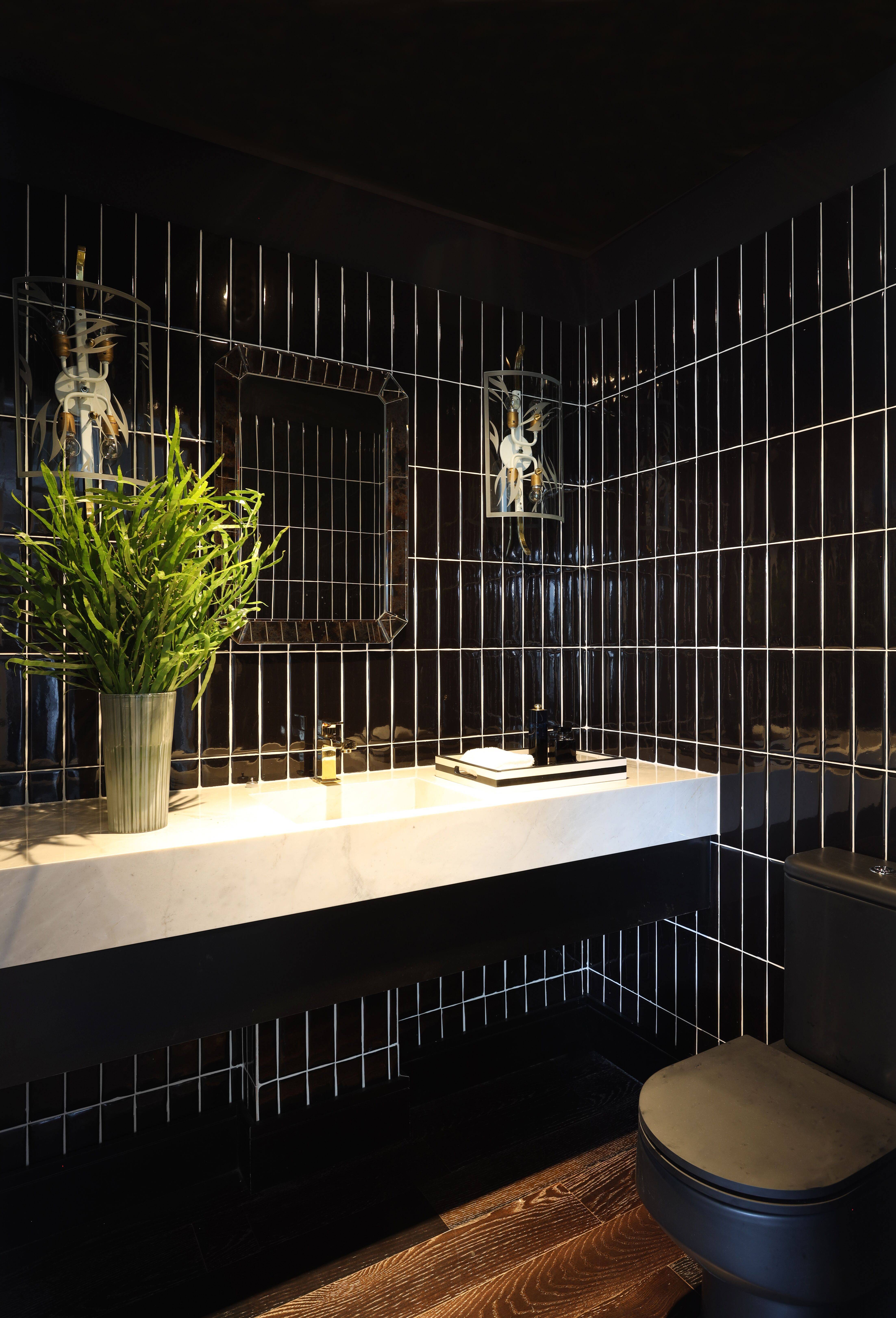No banheiro, azulejos pretos contrastam com a bancada em mármore branco. No banheiro, azulejos pretos contrastam com a bancada em mármore branco.