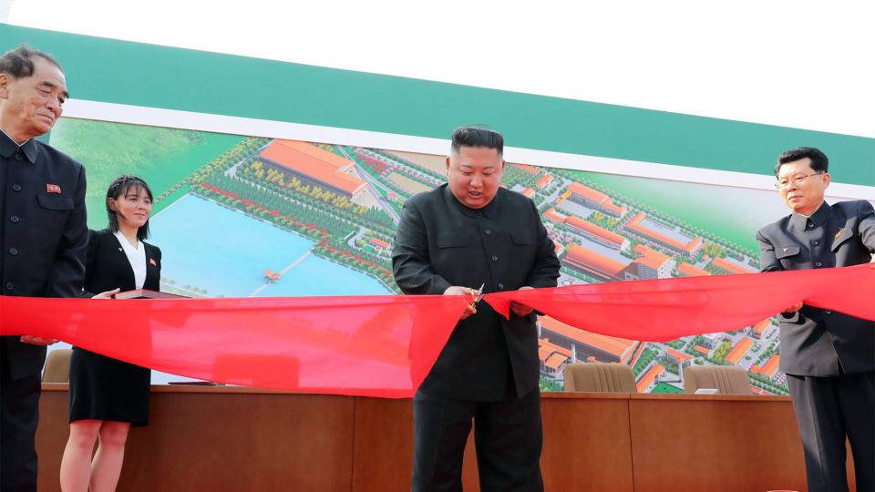 O ditador da Coreia do Norte, Kim Jon-Un, corta a fita de inauguração de uma fábrica
