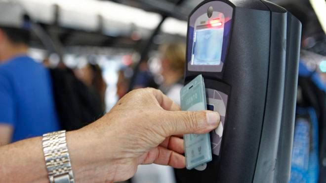 Dinheiro e Passagem de ônibus – Passageiros pagando a sua passagem de ônibus na capital paranaense na Praça Carlos Gomes. – Passageiros passando o seu cartão transporte para usar o sistema de ônibus da capital paranaense. Moedas e cédulas para pagar a passagem de ônibus que hoje dia 30/09/2015 está custando R$ 3,30.