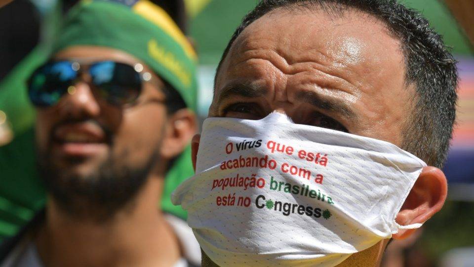 Manifestante participa de ato público, em Brasília, usando máscara com crítica ao Congresso.