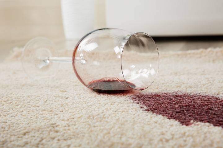 High Angle View Of Red Wine Spilled From Glass On Carpet High Angle View Of Red Wine Spilled From Glass On Carpet