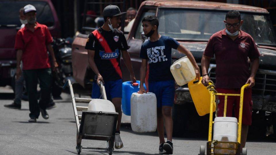 Números oficiais do coronavírus na Venezuela são “absurdos”, diz organização Pessoas transportam água em Caracas, Venezuela, durante a pandemia de coronavírus, 19 de maio de 2020