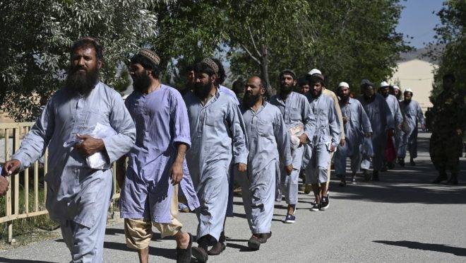 Prisioneiros do Talibã caminham em fila após serem liberados da prisão de Bagram, perto da base militar dos EUA na cidade